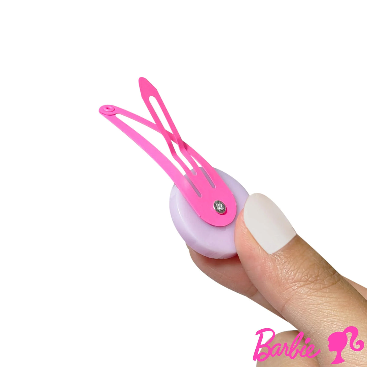 Barbie pink hair clip with rhinestone accent held by hand, Barbie logo in corner