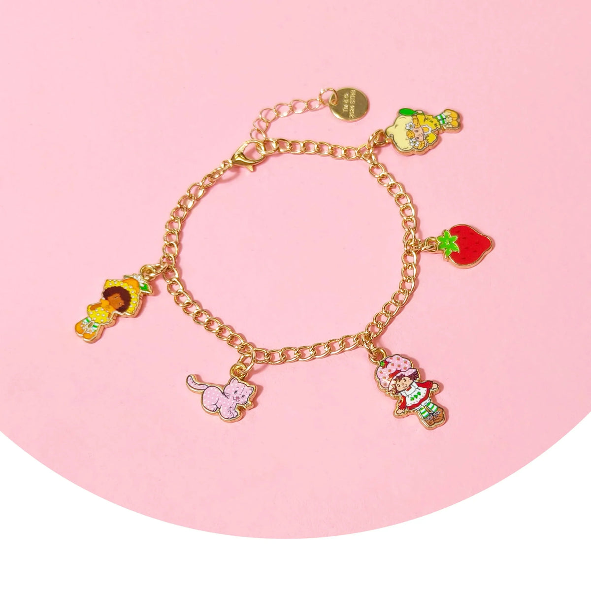 Strawberry Shortcake charm bracelet with colorful character and fruit charms on pink background