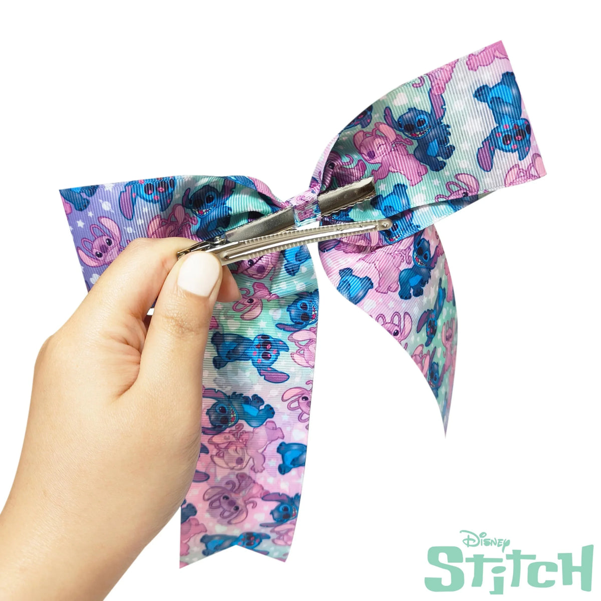 Hand holding Disney Stitch hair bow for girls with colorful Stitch pattern and clip