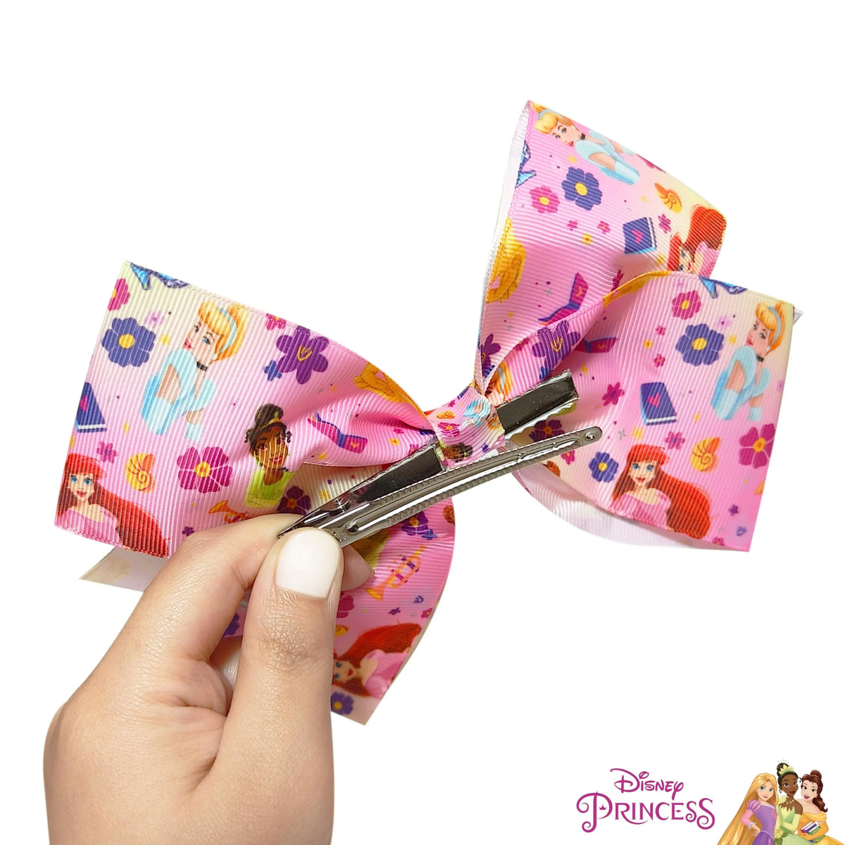 Disney Princess Hair Bow clip, pink with princess graphics, held in hand, girls' accessory