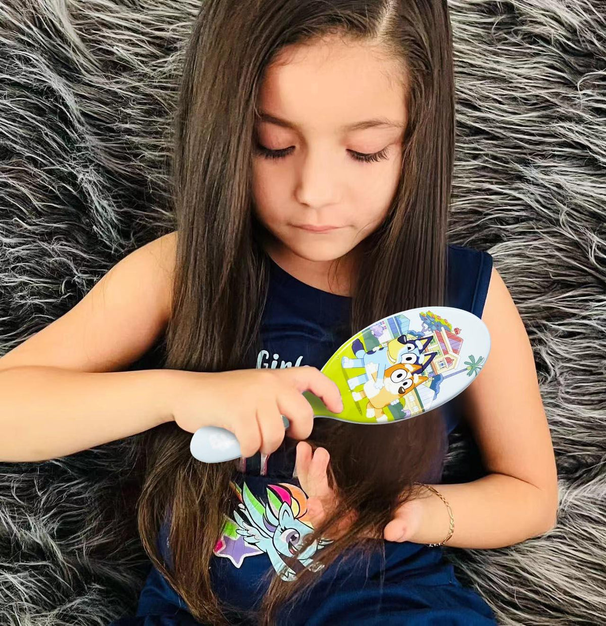 Girl brushing long hair with Bluey Hair Brush from LuvHer Shop, sitting on furry rug