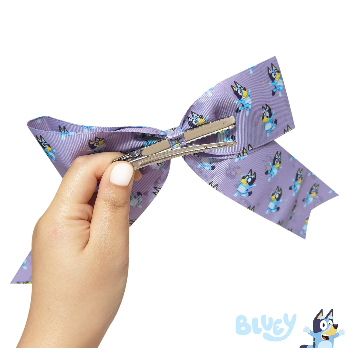 Hand holding Bluey hair bow, purple with Bluey cartoon print, LuvHer Shop girls' accessory
