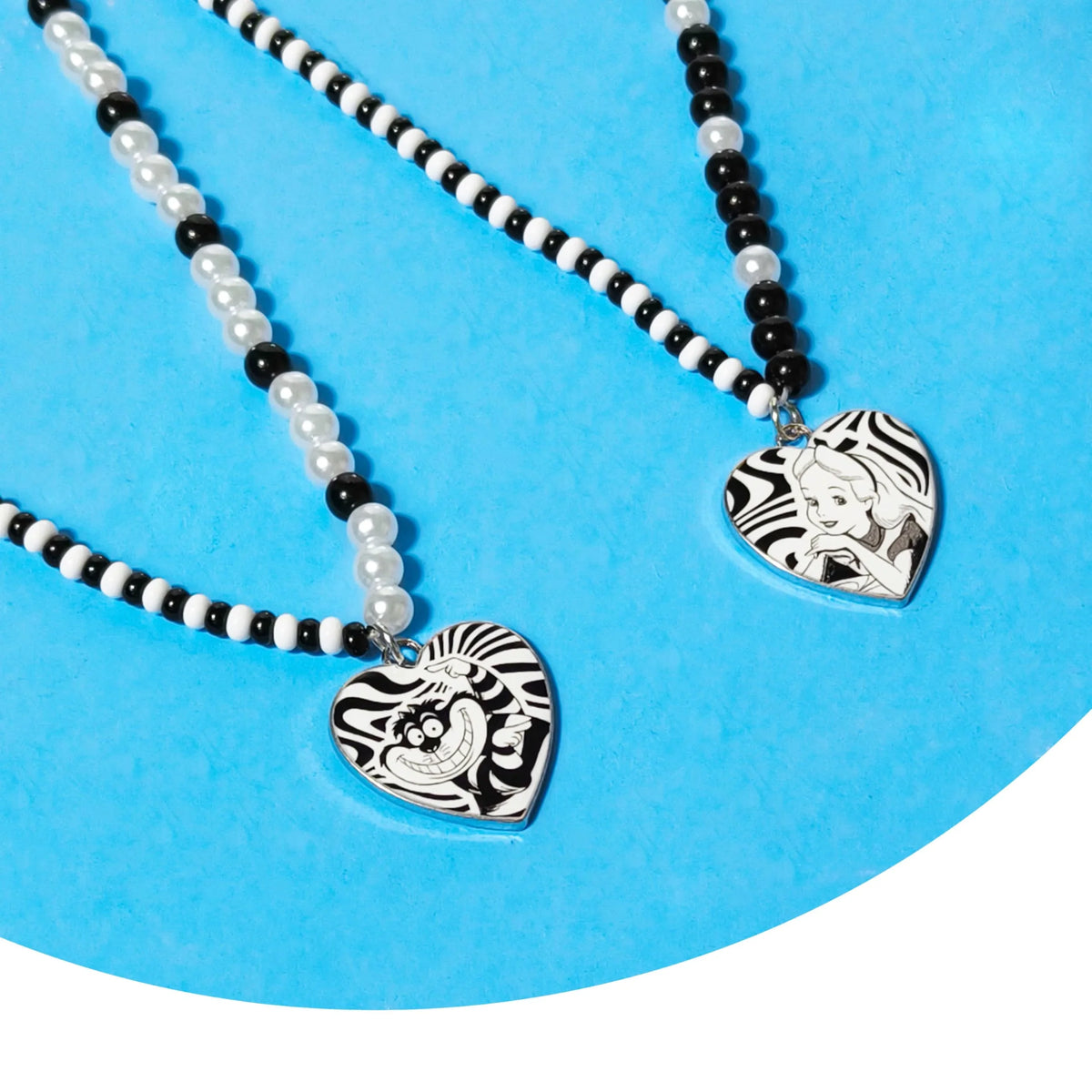 LuvHer Shop Alice in Wonderland best friends necklace set with heart-shaped charms and black, white, pearl beads on blue background