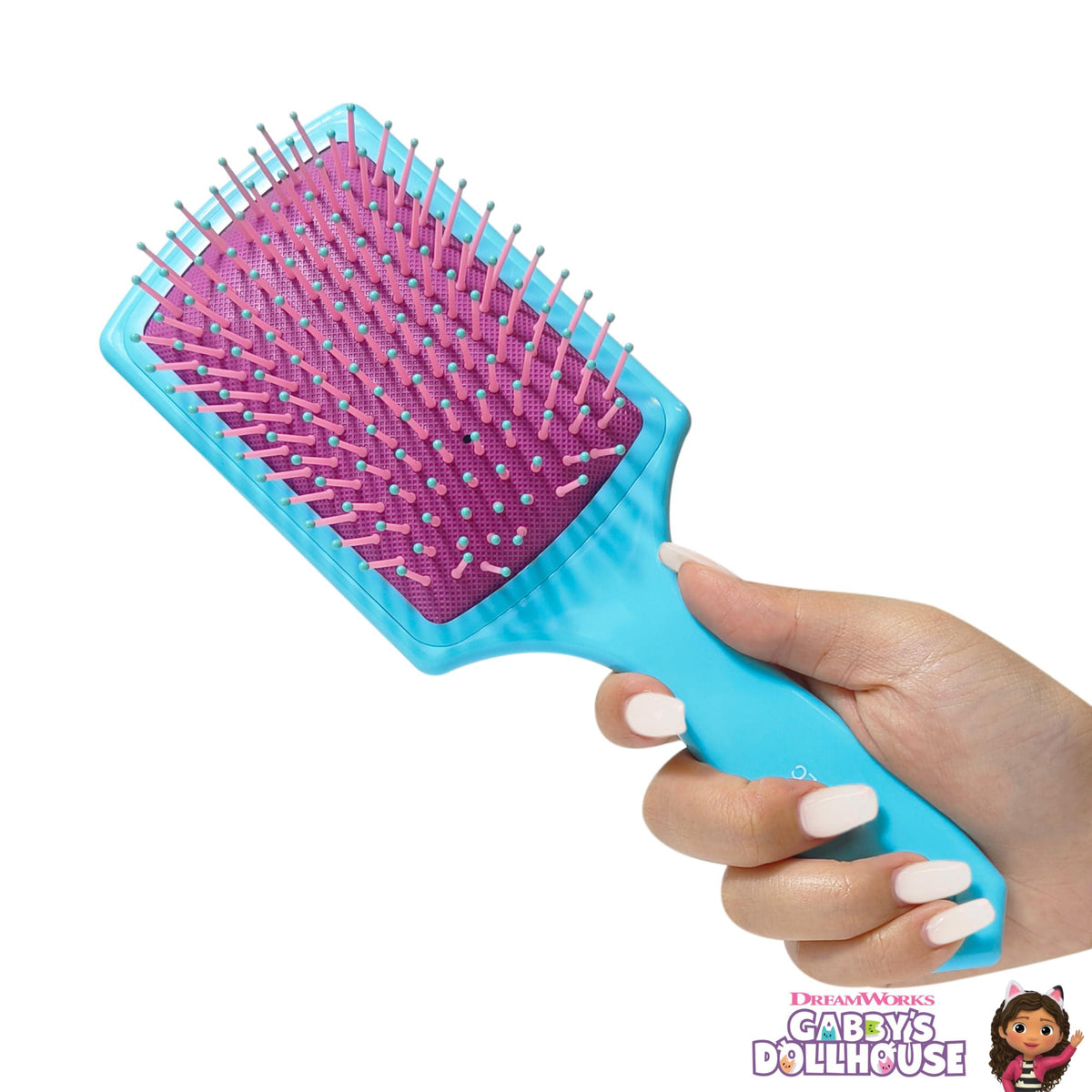 Gabby's Dollhouse paddle hair brush with blue handle and pink bristles, held in hand