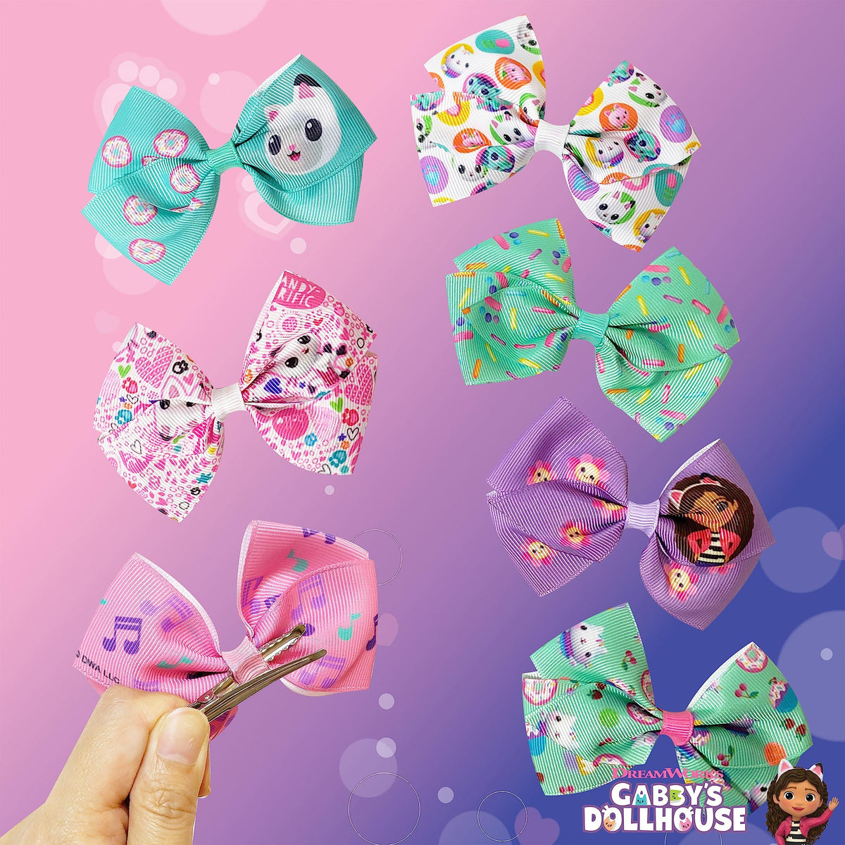 Gabby's Dollhouse hair bow set with colorful character designs on a pink and purple background